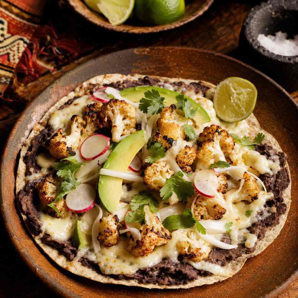 Tlayuda met geroosterde bloemkool, zwarte bonen en queso Oaxaca