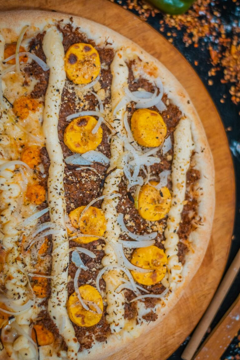 Delicious close-up of a gourmet pizza with cheese, sausage, and yellow tomato slices.